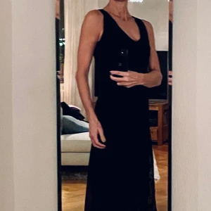 Svart cocktailklänning med spetsbroderier, stlk 36/S - Superfin cocktailklänning, perfekt för nyår, i dubbellager med en del underklänning och en yttre del  broderad spets. Vackert fall. Ärmlös. V-ringad. Som helt ny. Färg: svart  Stlk: 36/S 