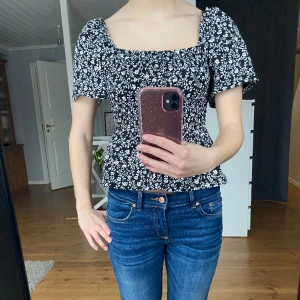 Blommig topp  - En fin svart och vit blommig topp som har snygga detaljer. Den är ifrån hm och är strl S. Den är knappt använd och är i bra skick!!!