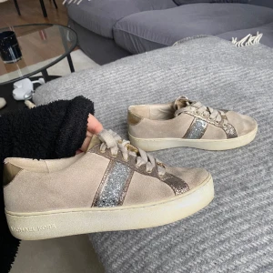 Sneakers  - Sneakers från micheal kors i guldig mocca. Nypris 2200kr. Använda men i fint skick. 