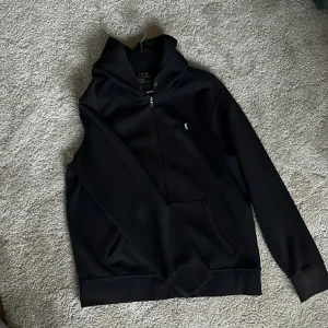 Polo zip-hoodie - Polo zip-hoodie i performance modellen. Lite solblekt på luvan och ärmarna längs ned. Storlek L men kan passa dig som har M.