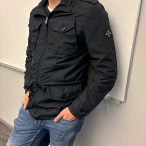 J.lindeberg jacka  - Jag säljer denna snygga J.lindeberg field jackan. Jackan är i mycket bra skick 9/10. Nypris på denna ligger runt 3500-4000 Modellen är för personer som är ca 185 cm.