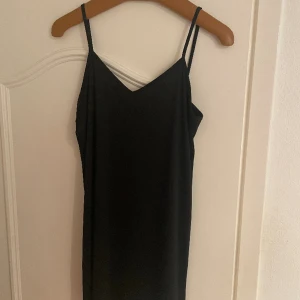 Svart kort klänning - Super fin klänning med tunna band i ett otroligt skönt material. Vet tyvärr inte storlek eller märket. Passar 36/38. Använt endast en gång