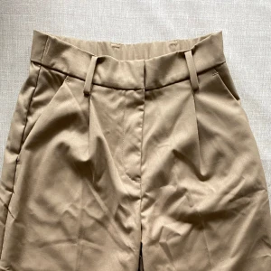 Kostymbyxor - Kostymbyxor i nyskick. High waist. Midjemått 31 cm. Total längd 106 cm.  Materialen är polyester och viskos. 