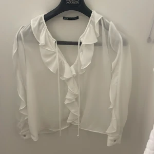 Vit zara blus - Superfin blus ifrån zara! Har två band som går att knyta ihop passar perfekt till festliga tillfällen, den kommer tyvärr inte till andvändnig här hemma. Andvänt fåtal gånger!