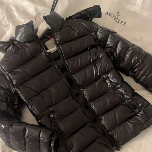 Moncler jacka bady  - Moncler jacka bady. Säljer då den tyvärr är för liten på mig. Storlek 1 (S). Finns en defekt, en liten reva vid luvan, den syns inte men man kan sätta lagningslapp. Annars jätte bra skick använd fåtal gånger. Dustbag med följer, givetvis äkta💞💞