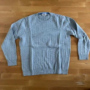 Grå tröja Murrey - Ljusgrå kabelstickad tröja från Murrey i stl XL, men sitter som en L
