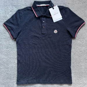 Moncler pike - Riktigt fin Moncler Piké. Nyskick (9,5/10) och köpt i somras från Monclers hemsida för 3100kr. Den är sparsamt använd och passar storlek S +- lite. Kvitto och tags medföljer självklart. Perfekt till vår och sommar.  Skriv för fler frågor/Carl