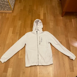 Sail Racing hoodie - Tröjan e nästan som ny förutom ett hål i armen som knappt syns. Hålet sitter på insidan av armen intill kroppen så syns inte när man har på sig den. 