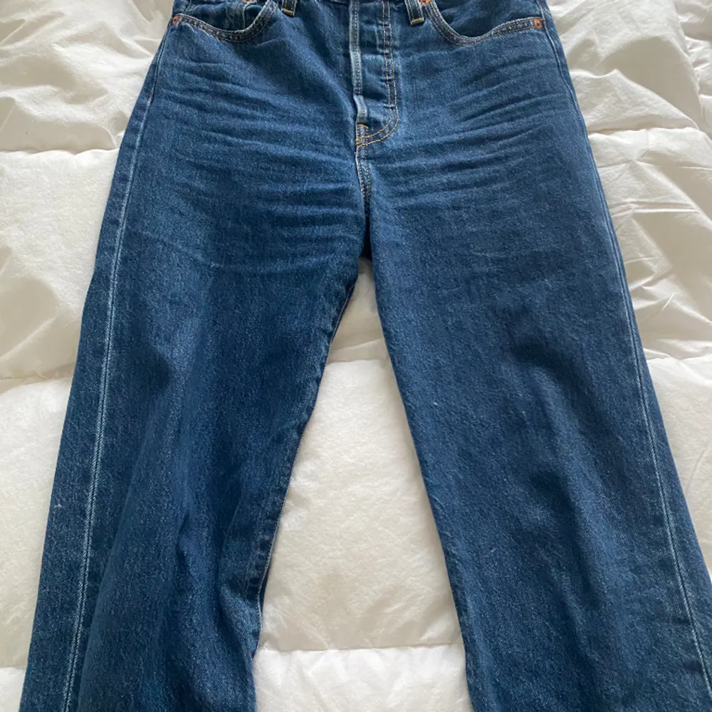 Blåa Levis jeans som är lite vida nertill, men ganska rak passform. Passar mig som är 162. Midjan är storlek 25/26. Jeans & Byxor.