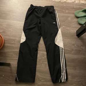 Adidas trackpants - Adidas vindbyxor/trackpants. Bra skick, inga defekter vad jag märkt. Midja: 37-48cm. Ytterben längd: 101cm. Innerben längd: 77cm. Benöppning: 22cm men kan justeras. Uppskattas som storlek M.