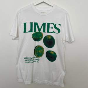 Vit T-shirt med lime-tryck från Atthemoment, storlek M, aldrig använd!