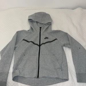 Grå Nike tech - VÄLDIGT bra skick. Köptes för 1,300 och säljer för 1.000. storlek xs. Köpte från Nike kids