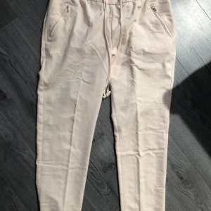 Kostym byxor mjukt material  - Kontum byxor mjukare material st 40 ljus rosa med guld detaljer från Lindex 