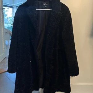 Svart kappa - Snygg svart lite lurvig kappa, knappt använd, för liten för mig.