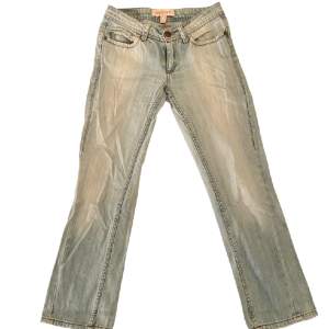 Supersnygga lågmidjade jeans med detaljer på fickorna! Knappen på ena bakfickan saknas, i övrigt i bra skick.                                   -Midjemått: 35 cm              -Innerbenslängd: 66 cm                  -Fotvidd: 18 cm