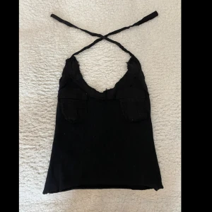 Fin stickad topp - Fin och bekväm stickad topp med ett knytbart band och två fickor på bysten!