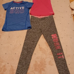 Set med träningskläder byxor tshirt linne 130-150 - Säljer nu detta set med träningskläder, ett rosa linne, en blå tshirt och gråa byxor. De är använda men i bra skick. Alla plagg är mellan 130-150 i storlek. 90 kr för alla!