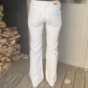 Lågmidjade vita jeans - Lågmidjade jeans från tommy hilfinger, midjemåttet är 36cm och innerbenslängden är 78cm💕