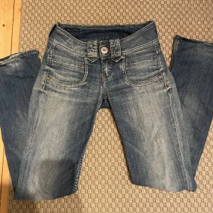 Bootcut Low waist jeans - Dåv slitning på ena knäet och hål på det andra. Lite slitning vid hälarna