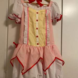 DONT PRESS BUY NOW Madoka cosplay, used a few times at conventions. Purchased for 700 kr, the wig is included in the price. One bow for the dress is missing (see picture). I do not sell the wig separately. Size M. Cats in home. The wig is styled. 