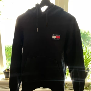Tommy Jeans Hoodie  - Säljer min gamla hoodie från Tommy Jeans då den ej passar mig längre, bra skick! Hör gärna av dig 