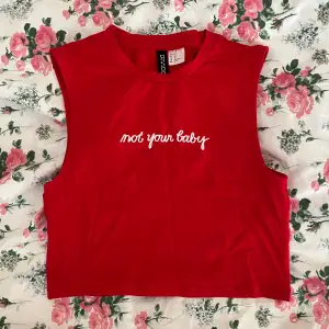 En röd tanktop / babytee med texten ”Not your baby” från H&M i strl XS!💓