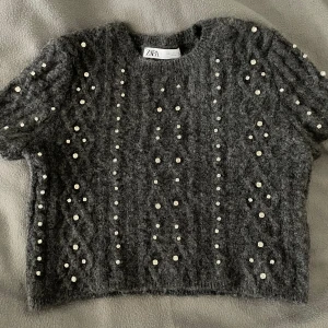Zara tröja - Säljer en oanvänd grå Zara tröja med silver pärlor på som är i storlek S, om ni vill ha fler bilder så skriv privat💗 Ps inga pärlor saknas💕