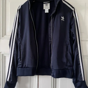 Adidas special edition - Cool glansig adidasjacka med snygg drappering på ryggen. I princip Oanvänd, mycket bra skick.