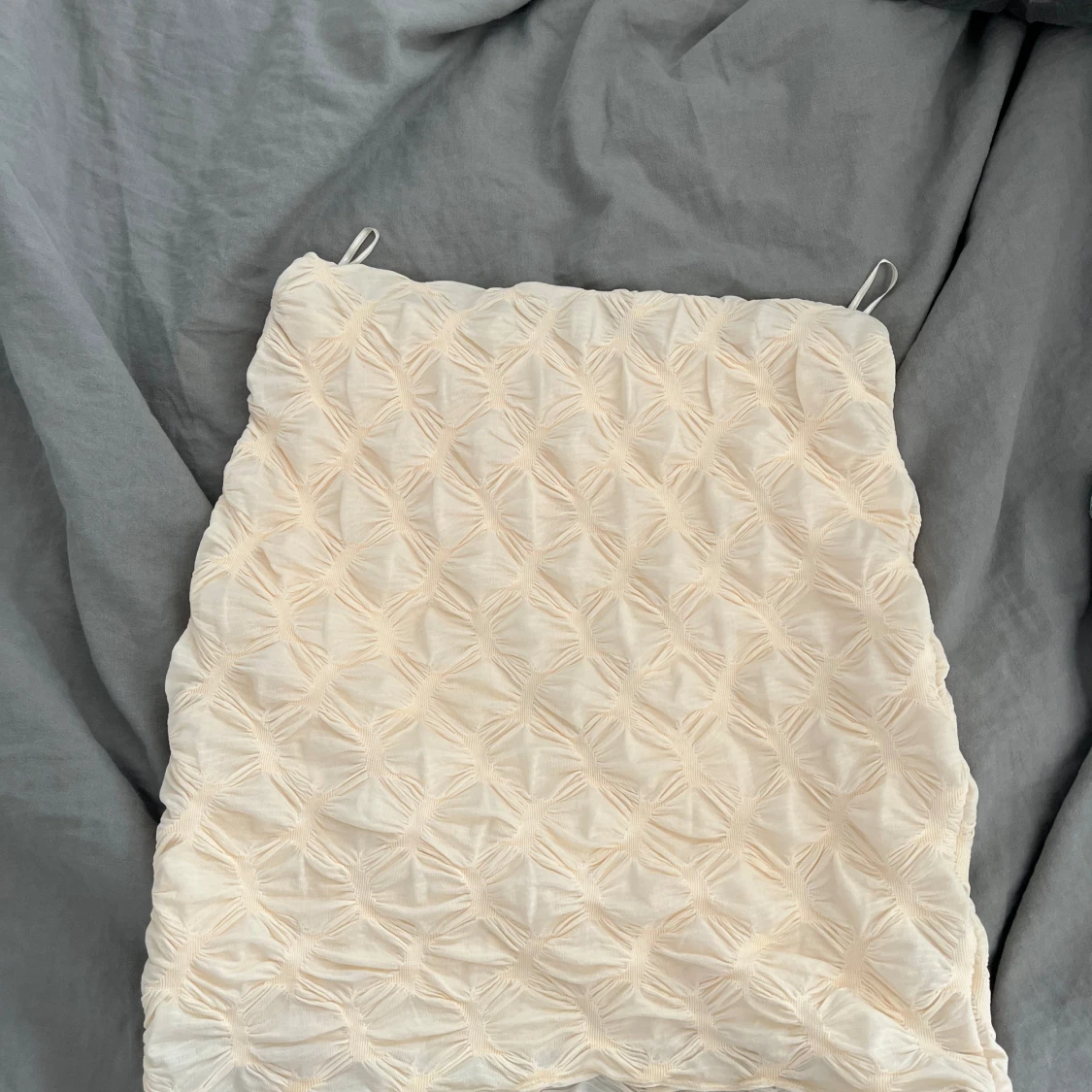 En kräm vit kort kjol