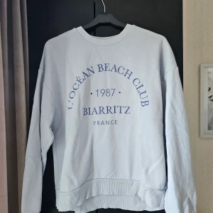 Ljusblå collagetröja med tryck  - En ljusblå collage tröja med tryck. Perfekt till en kjol på sommarn. Köpt på Ginatricot i storlek S från deras good collection. Den är i använt skick. 70% cotton 30% polyester