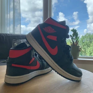 Jorden 1 Mid Black/Siren Red-White  - Säljer mina jorden 1 Mid  . Dom är använda fåtal gånger, är också i ett väldigt bra skick. Lådan är tillgänglig.