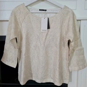 Guldskimrande topp med trekvartsärm strl S - Strl S Ny med lapp. Topp från Breakout woman, med trekvartsärm. Lite stelare, kraftigt tyg. Skimrar i guld.