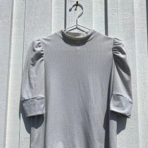 Trekvartsärmad blus  - Trekvartsärmad blus med puffärmar i glittrigt tyg