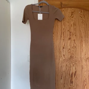 Klänning Zara - OANVÄND, PRISLAPP KVAR. Biege/sandfärgad klänning från Zara som aldrig kommit till användning. Storlek S. Använd gärna köp direkt! 