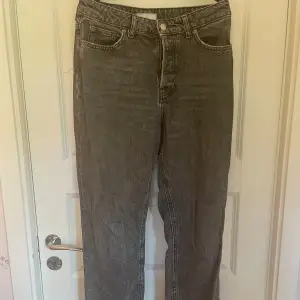 Ett par grå/svarta jeans i storlek 38. Jeansen har broderier på bakfickorna och är väl använda