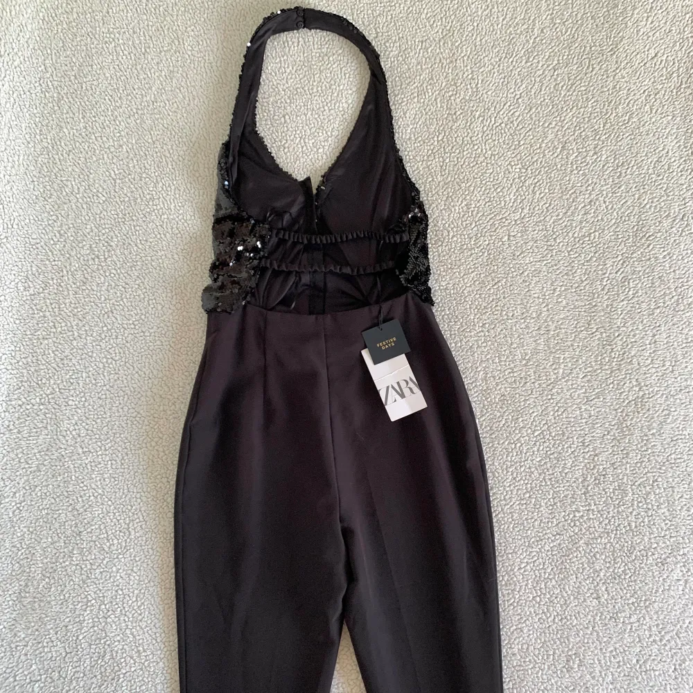 OTROLIGT snygg jumpsuit från ZARAs festive collection med en halterneck paljettväst insydd med ett par kostymbyxor. Paljettvästen stängs fram med hakar som en korsett. Ny med tags. Har någon liten tråddraggning på byxorna men inget som stör. 🌻. Mekot.