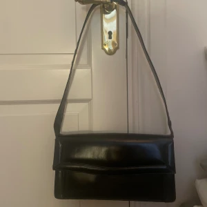 Svart vintage väska - Vintage väska med justerbar axelrem.