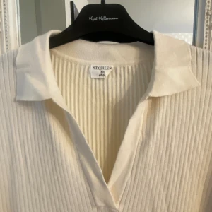 Helt ny, stickad klänning med slits - Helt oanvänd, vit stickad klänning. Väldigt bekväm och med snygga slitsar på båda sidor.  Prislappen sitter kvar!! Färg: krämvit Nypris: 200kr