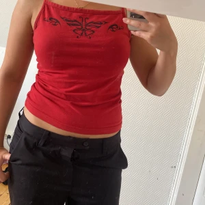 Topp - Ett rött fint linne med ett coolt tryck på. Är i väldigt fint skick. 💞