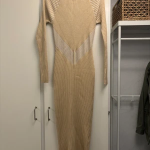 Stickad klänning med öppen rygg - Snygg figurnära klänning, helt oanvänd.