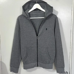 Ralph Lauren hoodie - En grå Ralph Lauren zip hood i ny skick, nästintill aldrig andvänd!  Inga defekter eller liknade. Pris kan diskuteras! (Obs inga snören finns)