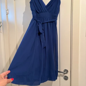 Superfin blå festklänning - Festklänning i modernaste färgen! Fin urringning och fall. Inga anmärkningar. Nytvättad och redo att bäras på festen igen!   Passar storlek XS-S