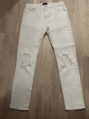 Liquor n poker jeans vita - Vita jeans från liquour n poker storlek 34, ripped knees jeans, perfekt för sommaren.