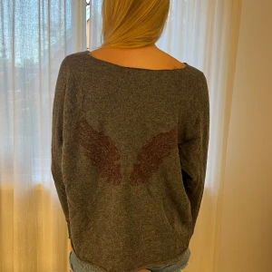 Hunkydorytröja - Supercool stickad tröja från Hunkydory med vingar i ryggen. Smått nopprig på armar men kan tas bort lätt. 