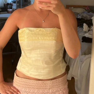 Korsettopp  - Superfin ljusgul korsettopp! Den är omsydd från en klänning så kanterna är lite ojämna men det är inget man tänker så mycket på.