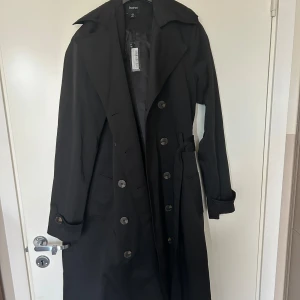 Trenchcoat - Kappa ifrån Bohoo helt oanvänd, ny med prislapp. superfin! 
