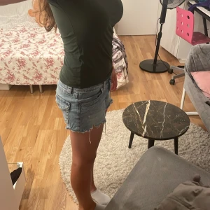 T-Shirt  - Materialet är stretchigt och skönt att ha på sig. Modellen är tajt det är en urringning på framsidan. 