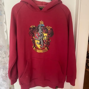 Gryffindor hoodie - Harry Potter Gryffindor Hoodie i snygg vinröd! Storlek L unisex. Jag har haft den som skön oversize. En liten fläck på fickan, inget som syns så mycket 🍓