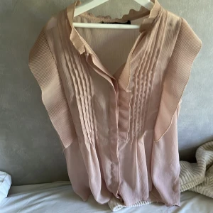 Rosa blus från zara - En fin rosa blus som är ganska genomskinlig ifrån zara som är i storlek xs, blusen är varsamt använd men kom med en liten slit där knapparna sitter vilket man kan se på bild nr 2 och därav ett lite billigare pris som jag satt.