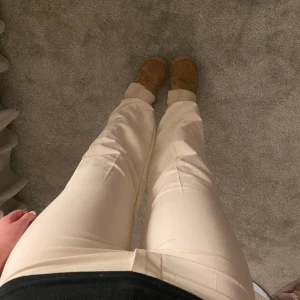 Kostymbyxor - Raka fina kostymbyxor i krämvit/ljusbeige storlek 38 men insydda för o sitta tajt men går o sprätta upp till den från början vida modellen. Mellanhög midja